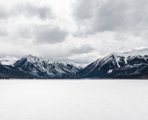 body of water near mountain peak during daytime