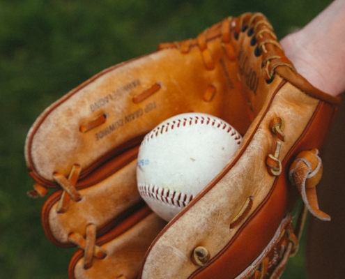 brown leather baseball mitt with white baseball