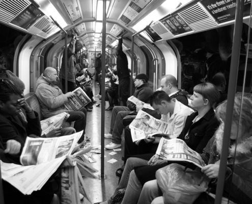 grayscale photo of people sitting on train chairs