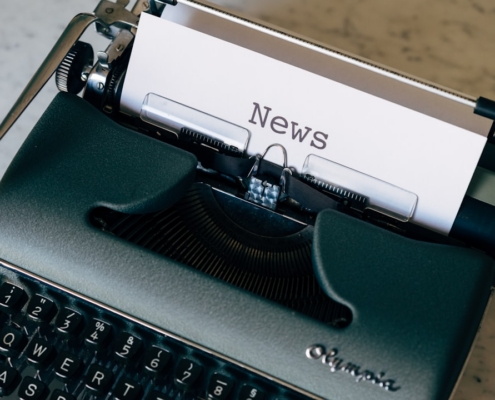 green and white typewriter on brown wooden table