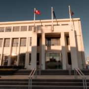 Modern building entrance with flags under a clear sky
