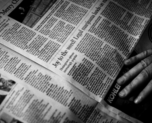 person's right hand near newspaper
