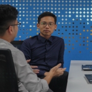 two men sitting at a table talking to each other
