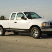 White pickup truck parked on a paved road.