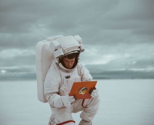 woman in white long sleeve shirt holding orange smartphone
