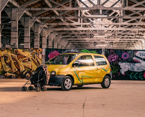 yellow 5 door hatchback parked beside brown wooden wall