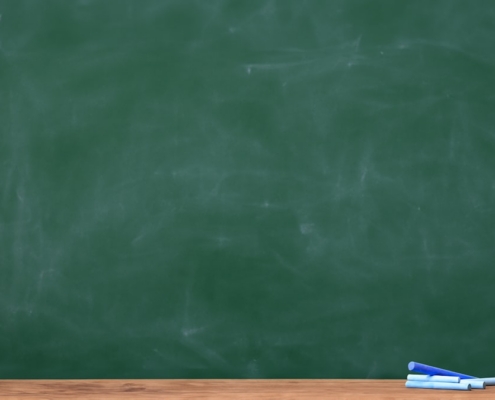 a blackboard with a chalkboard and two pens on it