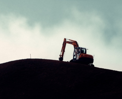 a bulldozer on top of a hill on a cloudy day
