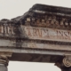 a close up of a stone arch with a sign on it