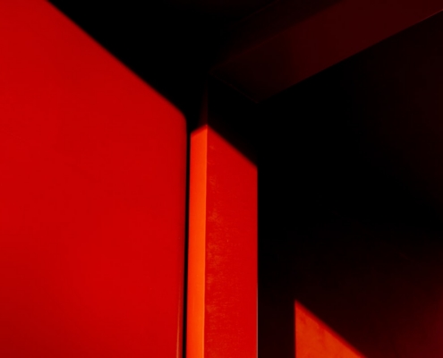 a close up of a red wall with a clock on it