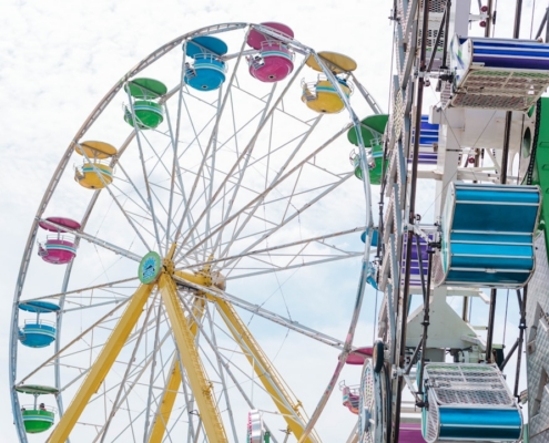 a ferris wheel with colorful seats on a cloudy day