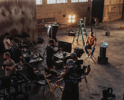 a group of people standing around a camera set up