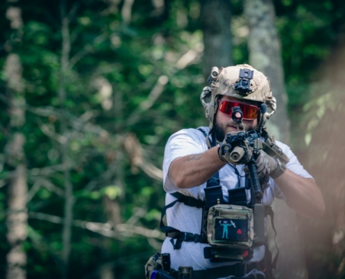 A man with a paintball gun in the woods