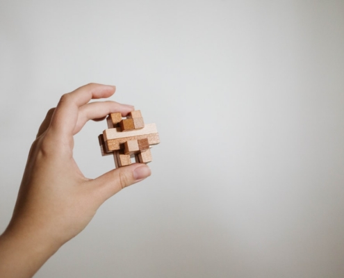 a person holding a wooden toy in their hand