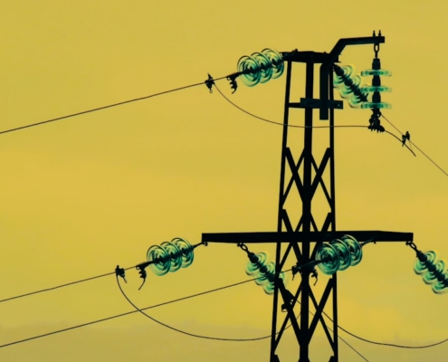 a power line with a yellow sky in the background