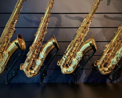 a row of saxophones lined up against a wall