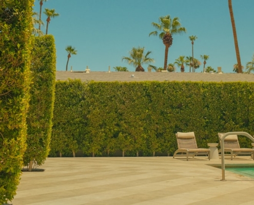 A swimming pool with lounge chairs and an umbrella