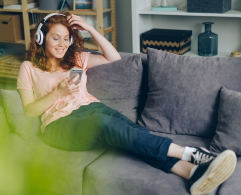 a woman sitting on a couch listening to music
