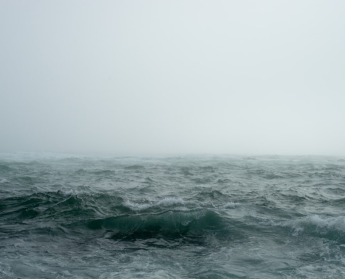 body of water surrounded by fog