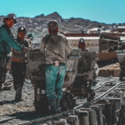 construction workers standing near wheelbarrows near mountain