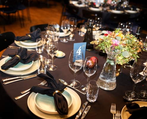 Elegant table setting with floral centerpiece and wine glasses.