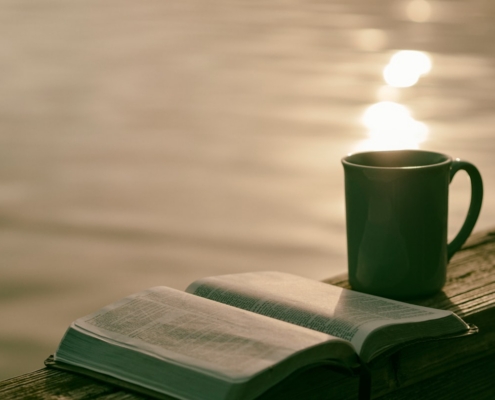 green ceramic mug beside book