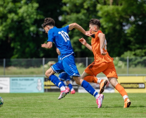 man in blue and orange jersey shirt running on green grass field during daytime