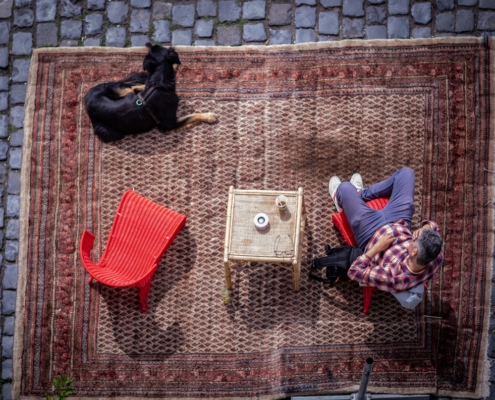 man in white long sleeve shirt lying on red and white rug