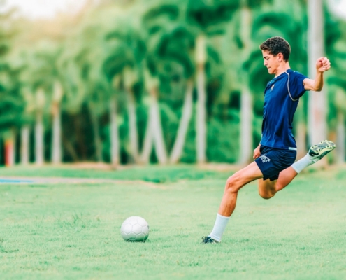 man trying to kick soccer ball