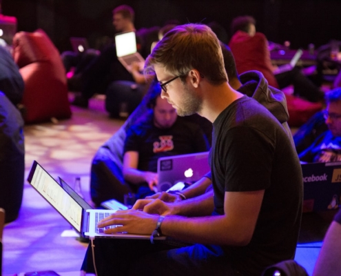 man using laptop in front of brown chair