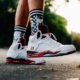 person wearing white-black-and-orange Air Jordan 5 shoes