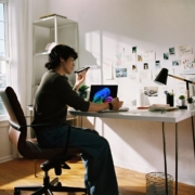 Person working at desk with laptop and phone.