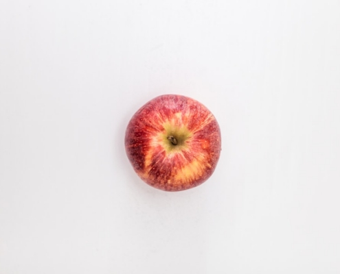 red apple fruit on white table
