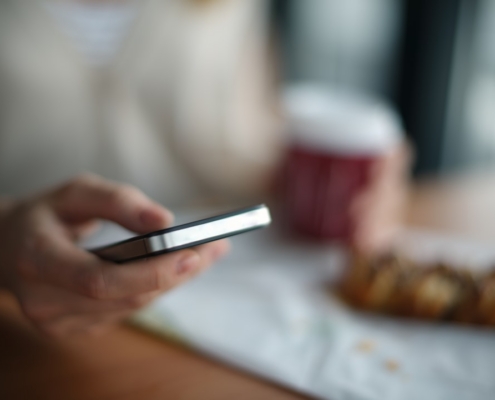 selective focus photography of person holding gray phone