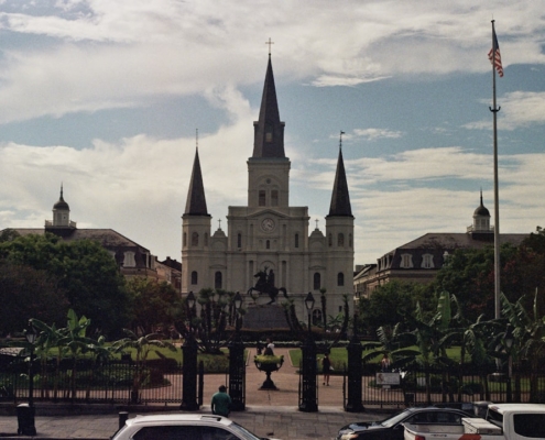 Several cars parked in a parking lot in front of a church