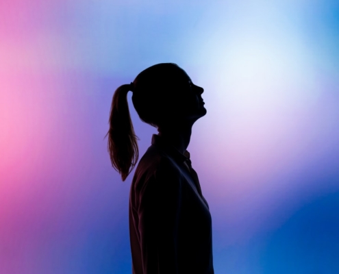 silhouette of woman wearing black hat and black coat