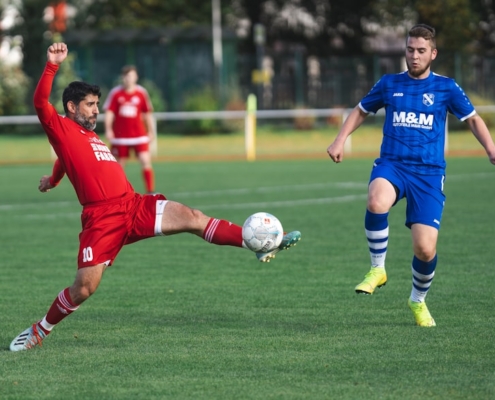 soccer players in red and blue jersey shirt and blue shorts