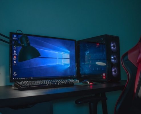 turned on desktop computer set with black and gray leather gaming chair