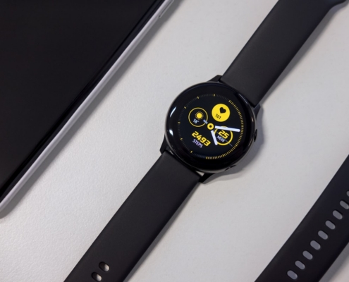 turned-on black smartwatch on white surface
