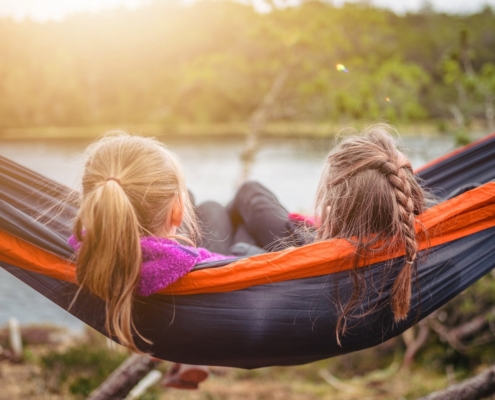 two women lying on hammock