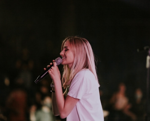 woman in white t-shirt singing