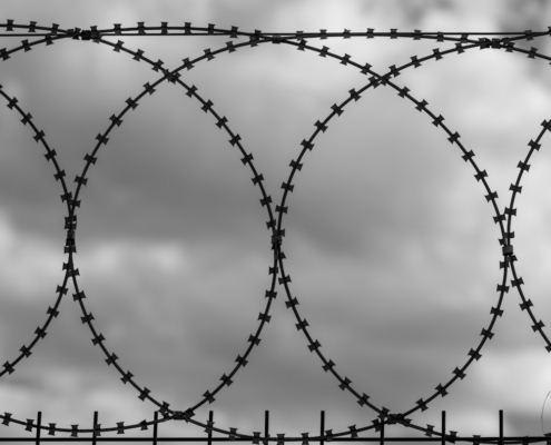 a black and white photo of a barbed wire fence