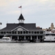 a boat dock with a building and a flag on top of it