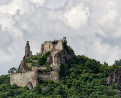 a castle sitting on top of a lush green hillside