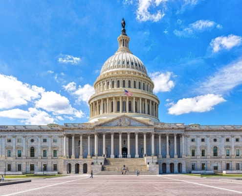 a large building with a dome and a flag on top with United States Capitol in the background