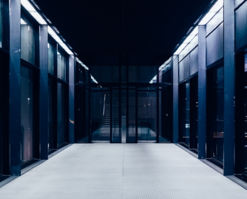 a long hallway with glass doors leading to another room