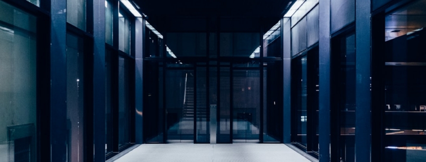 a long hallway with glass doors leading to another room