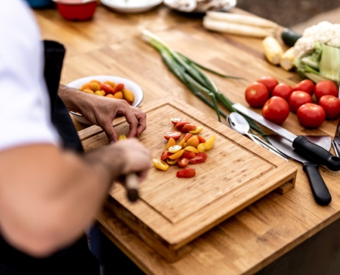 a person cutting up vegetables on a cutting board