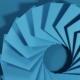 a spiral of blue paper on a blue wall