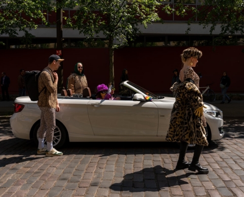 a woman standing next to a white convertible car